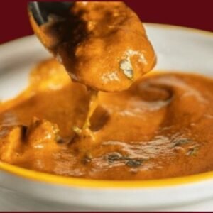 Spicy Vindaloo curry served in a copper bowl with tender meat chunks and rich red gravy, garnished with fresh cilantro.