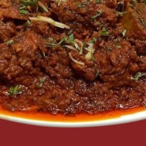 Bone-in mutton pieces in thick reddish-brown spicy gravy, garnished with fresh coriander