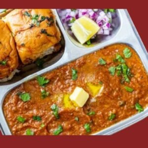 Pav Bhaji served with buttered buns, chopped onions, and lemon wedge on a plate